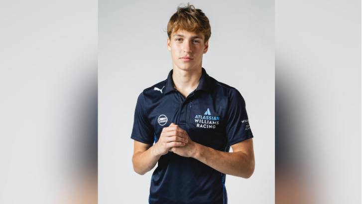 Bondarev in a WIlliams Racing branded T-shirt, posing for a headshot. He is clutching his hands in front of his chest.