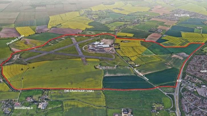 A graphic which illustrates the proposed development area, using an aerial shot of fields, containing the airport runways, with a red line marking the boundary of the local plan