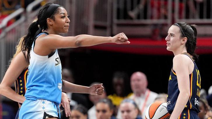 Angel Reese of the Chicago Sky punches the air while Caitlin Clark of the Indiana Fever looks on