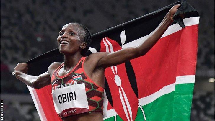 Hellen Obiri with a Kenyan flag celebrating her silver medal in the women's 5,000m at the Tokyo Olympics