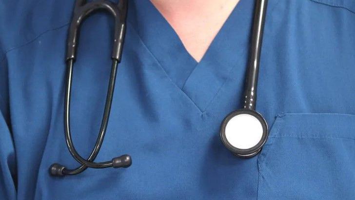 Stock image of doctor wearing blue tunic with stethoscope around their neck