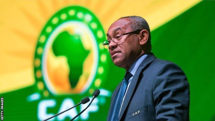 Caf president Ahmad Ahmad speaks on stage next to confederation logo