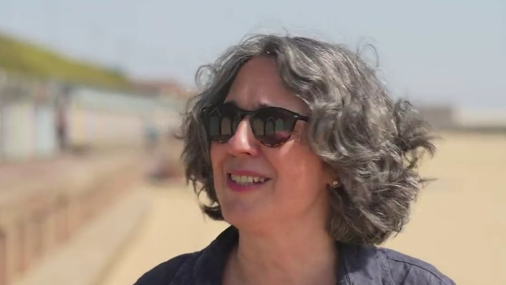 Genevieve Christie in sunglasses on a beach 