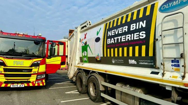 A recycling lorry and a fire engine parked on a road