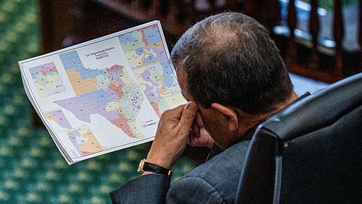 A man looks down at a map of the new voting districts in Texas