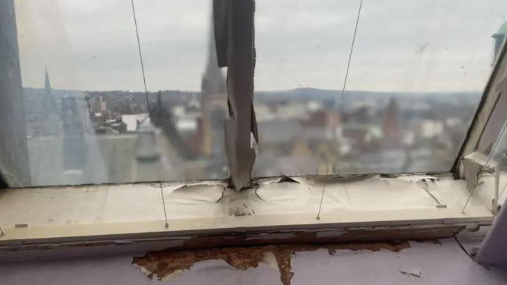 An old battered  window frame looking out on a blurry city scape