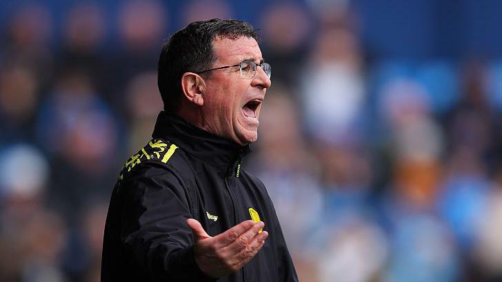 Burton Albion head coach Gary Bowyer shouting on the sidelines with his arm slightly raised