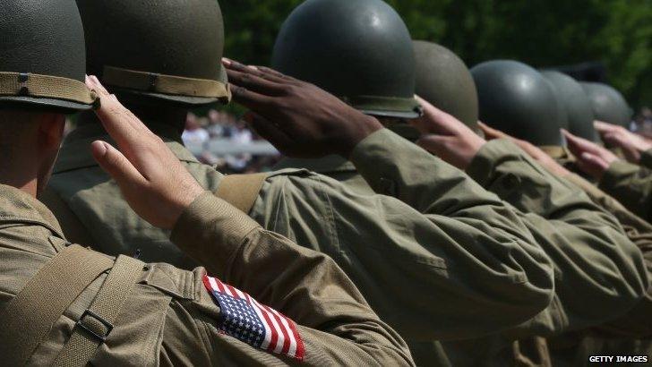 World War II re-enactors salute while the National Anthem plays during ceremony commemorating 70th Anniversary of VE Day at the National World War II Memorial