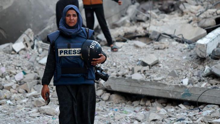 Photojournalist Doaa Albaz is photographed in the ruins of Rafah City, rubble all around her.