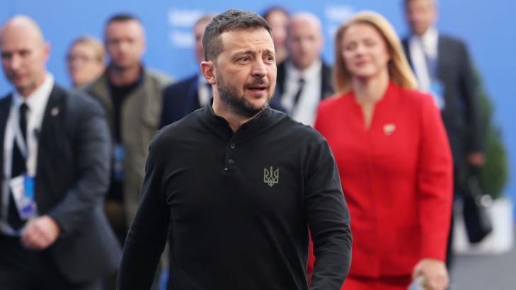 Ukraine's president Volodymyr Zelensky wearing a black shirt with a Ukrainian trident motif arrives for a European summit in Hungary with dozens of other leaders