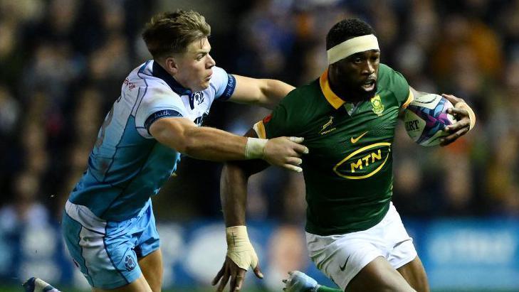 Siya Kolisi of South Africa runs with the ball whilst under pressure from Huw Jones of Scotland during the Autumn Nations Series 2024 match between Scotland and South Africa at the Scottish Gas Murrayfield 