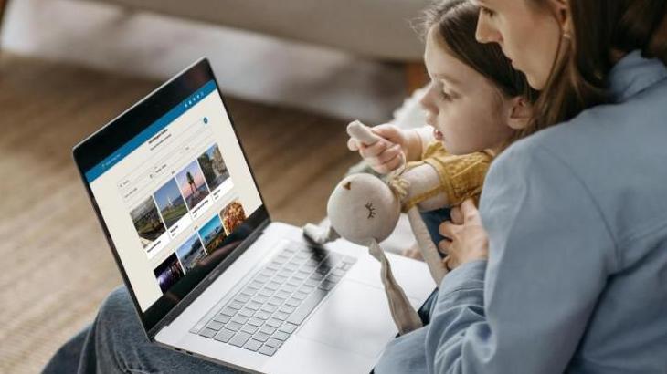 Child with an adult looking at images on a laptop