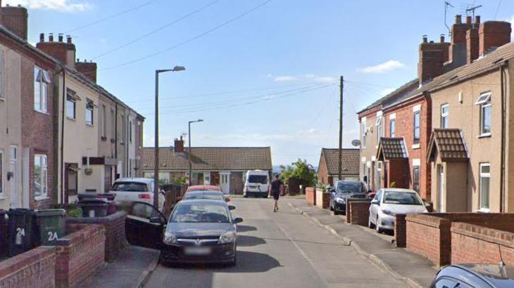 Street view of Addison Street. Cars are parked on either side of the road.