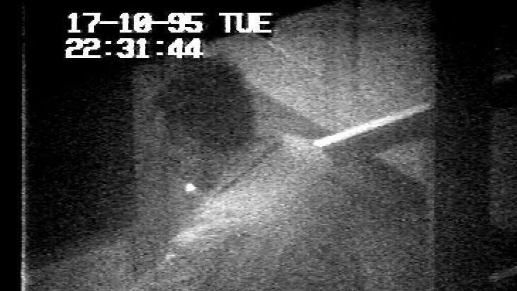 A grainy black and white image showing a man side on