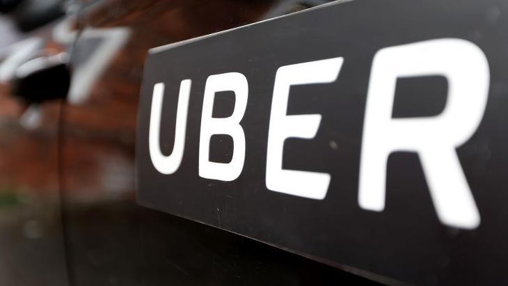 Uber sign, white writing on black vehicle