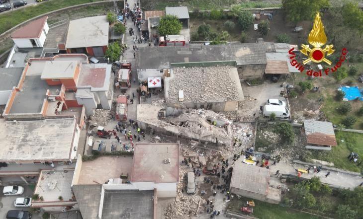 Taken from a drone, two large holes can be seen in a roof lying on top of rubble