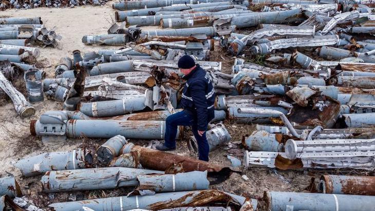 TOPSHOT - This aerial picture taken on December 7, 2022 shows an expert of the prosecutor's office examining collected remnants of shells and missiles used by the Russian army to attack the second largest Ukrainian city of Kharkiv, amid the Russian invasion of Ukraine. (Photo by Oleksii FILIPPOV / AFP) (Photo by OLEKSII FILIPPOV/AFP via Getty Images)
