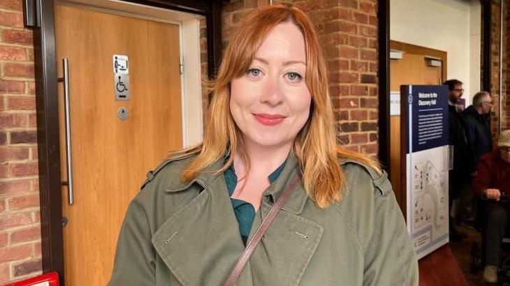 Amy O'Callaghan in a coat with strawberry-blonde hair