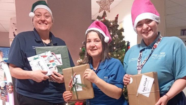 Staff at a Manchester children's hospital with gifts donated by Ariana Grande.