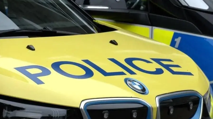 A yellow bonnet of a car with the word Police on it in blue.