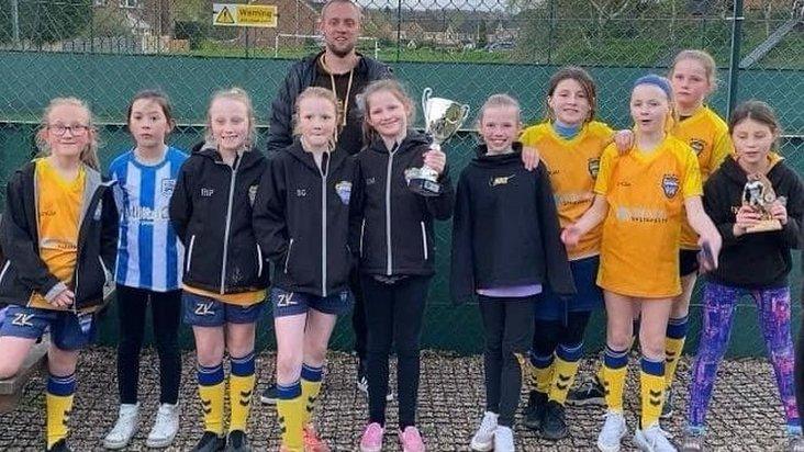 Girls team holding the cup