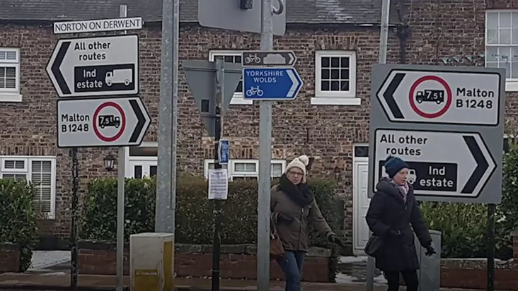 Two signs saying "Malton B1248" point at each other on different posts, meaning they indicate different directions.