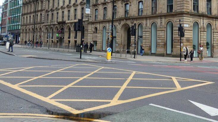 A yellow box junction is painted on a road outside a hotel in Manchester