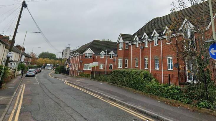 A screenshot from Google street view showing a residential road with houses on either side, and double yellow lines running next to the kerbs.