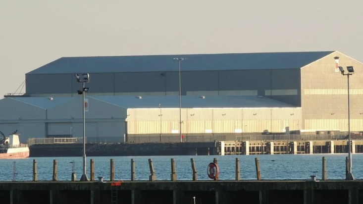 The yard's waterfront is dominated by large grey-coloured sheds.