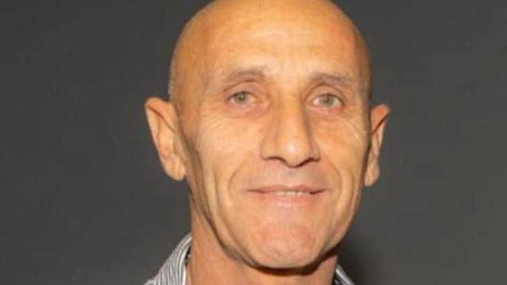 Yair Yaakov looking straight at the camera. He is bald and has grey eyes. He is wearing a striped shirt and smiling slightly.