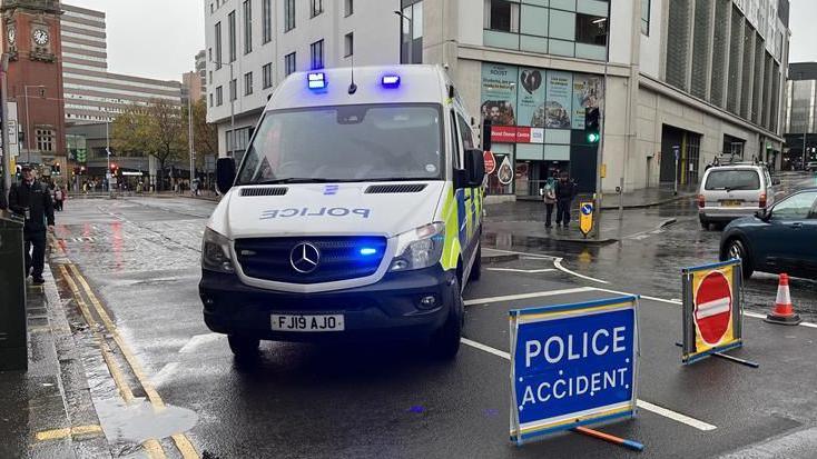 A police riot van parked across the road at the scene of the crash 