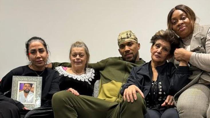 A picture of Anthony Joshua sat with four women