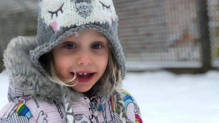 Amelia was pictured smiling at the camera - she wore a grey woolly hat with an animal face design and a bright winter coat. There was snow in the background.