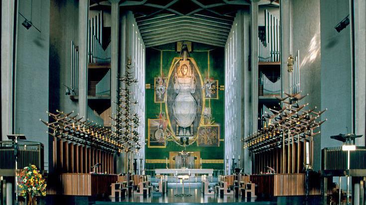 The nave of the cathedral, or the central part of the building, with a view of the tapestry, Christ in Glory, by Graham Sutherland, which depicts the risen Christ in an aura of light in heaven.