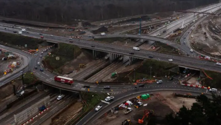 An aerial view of M25 junction with the A3 which shows roadworks going on around the roads and trees just visible around the edges.