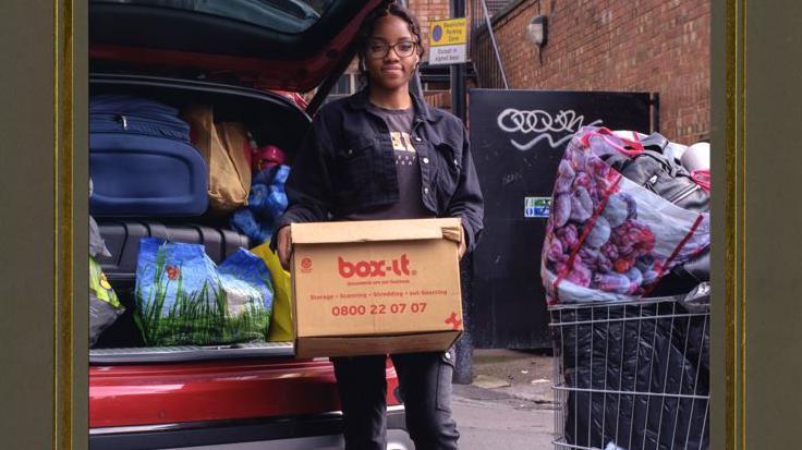 A student holding a box of belongings