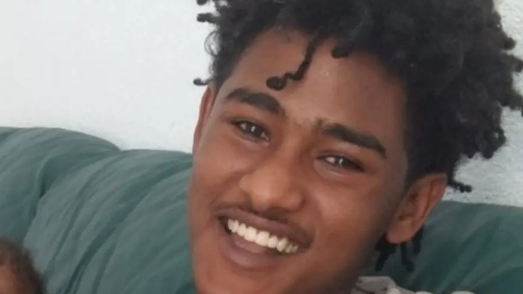 A close-up of a young man smiling towards the camera