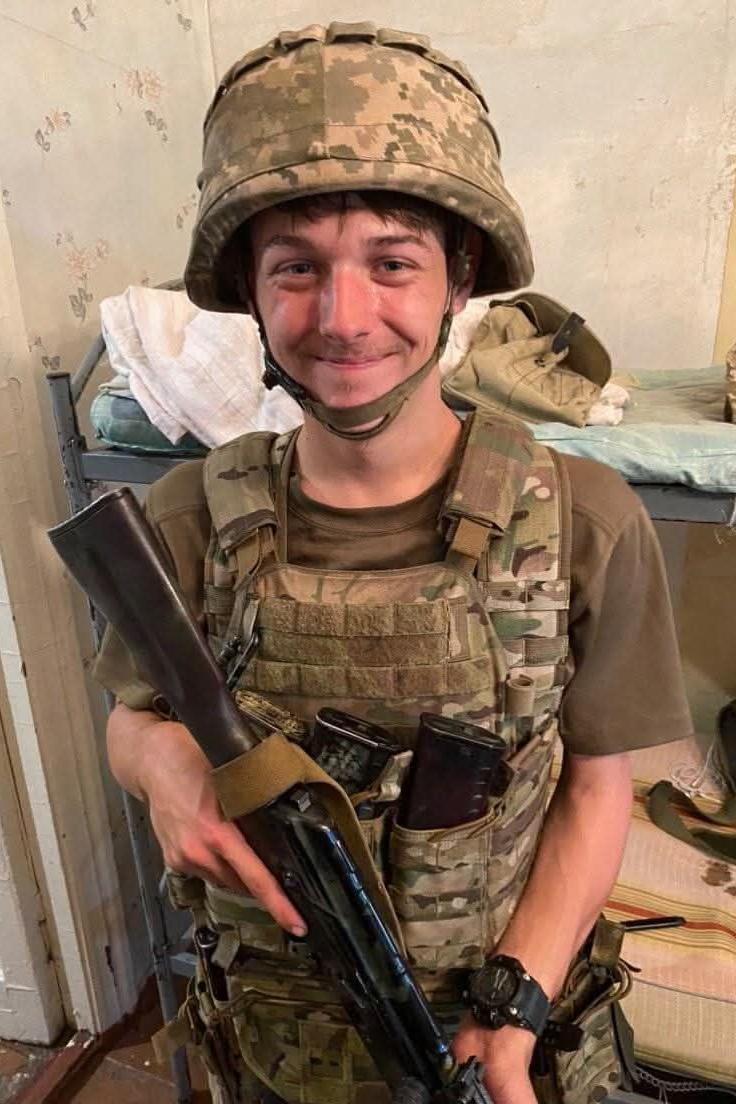 James Wilton pictured wearing army camouflage clothing, including a helmet and vest, while holding a rifle.