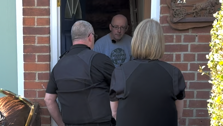 An image showing two bailiffs talking to a man who is standing in a doorway of his home.