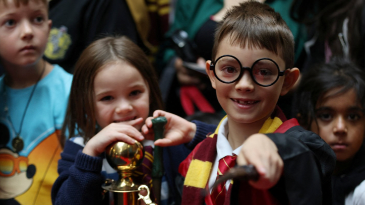 Harry Potter fan, 8, holds a wand during Back to Hogwarts Day at Kings Cross Station in London,