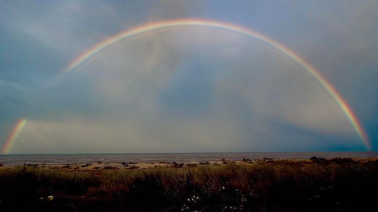 A rainbow above a beach.