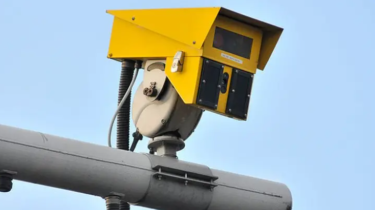 An ANPR camera - it is a yellow device sat on top of a grey metal pole.