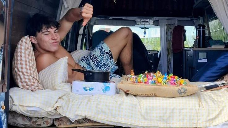 Milo Beimers pictured on a bed in the back of a van