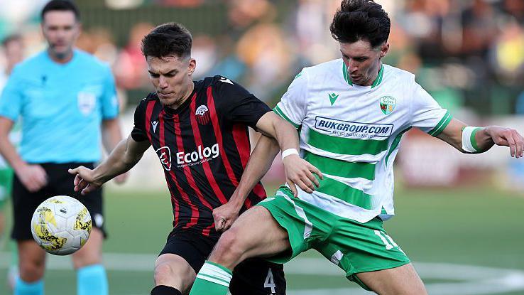 Saints' Rory Holden battles for possession with Reshat Ramadani