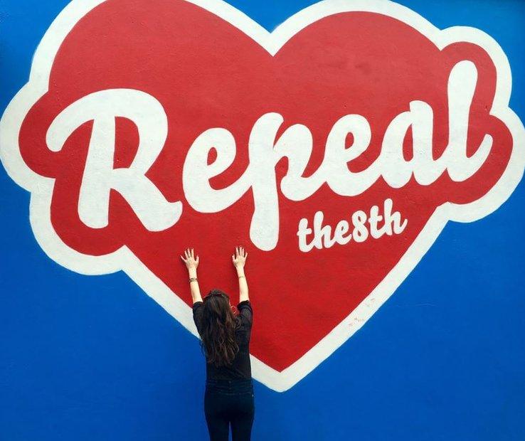 Photo of woman hugging mural