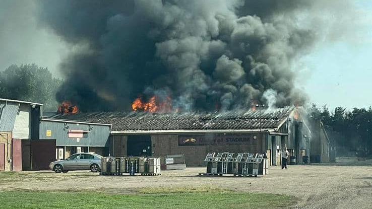 Flames and smoke coming from a large barn