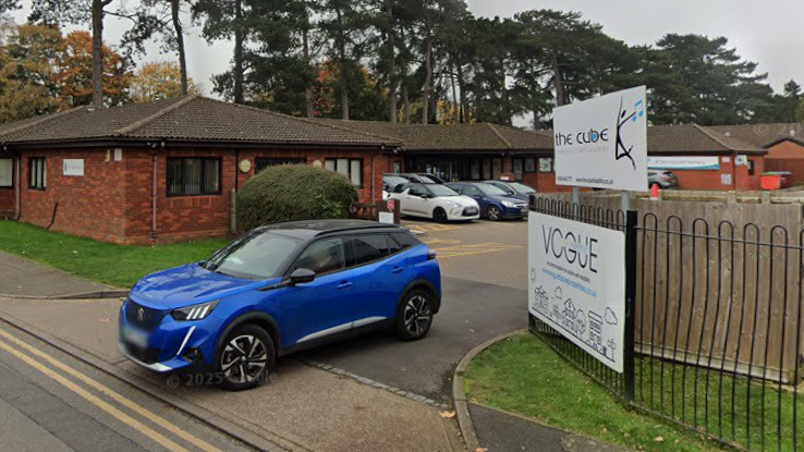 The outside of a Vogue Future Living Limited service in Northampton. It is a one storey building and there is a blue car driving out of the entrance.