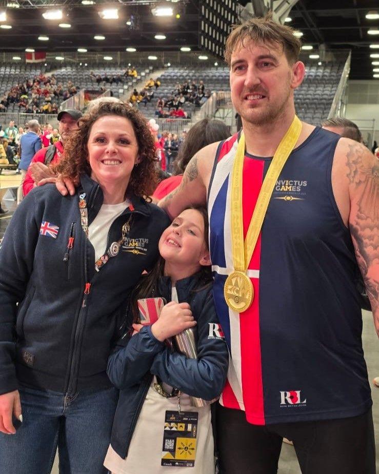 Wife Claire with Ben and one of their daughters in Vancouver. Ben has a gold medal around his neck.