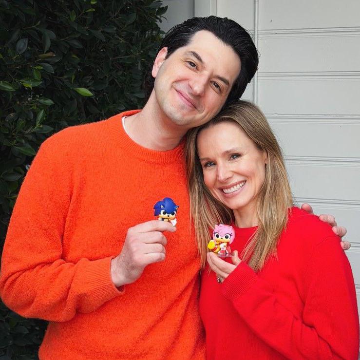 Besn Schwartz and Kristen Bell holding figures of the characters they voice and smiling
