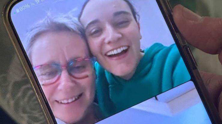 Mandy and Emily Damari hug as they speak on a video call after her release